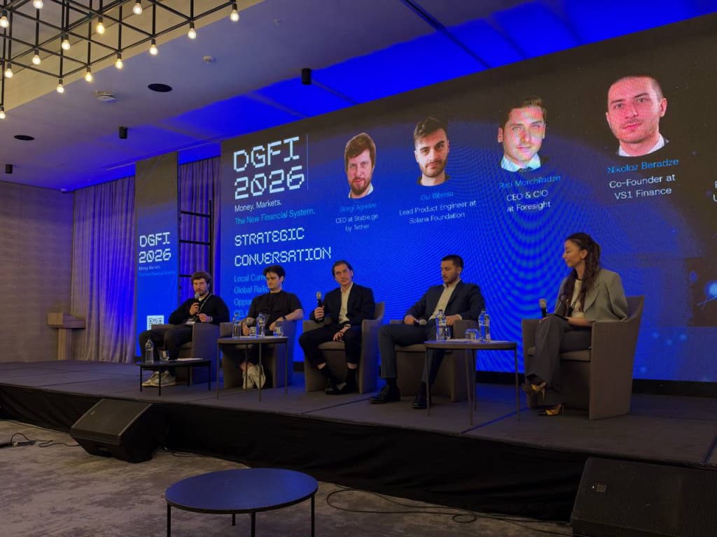 Full DGFI 2026 Strategic Conversation panel on stage, with the LED wall naming Gui Bibeau as Lead Product Engineer at Solana Foundation.